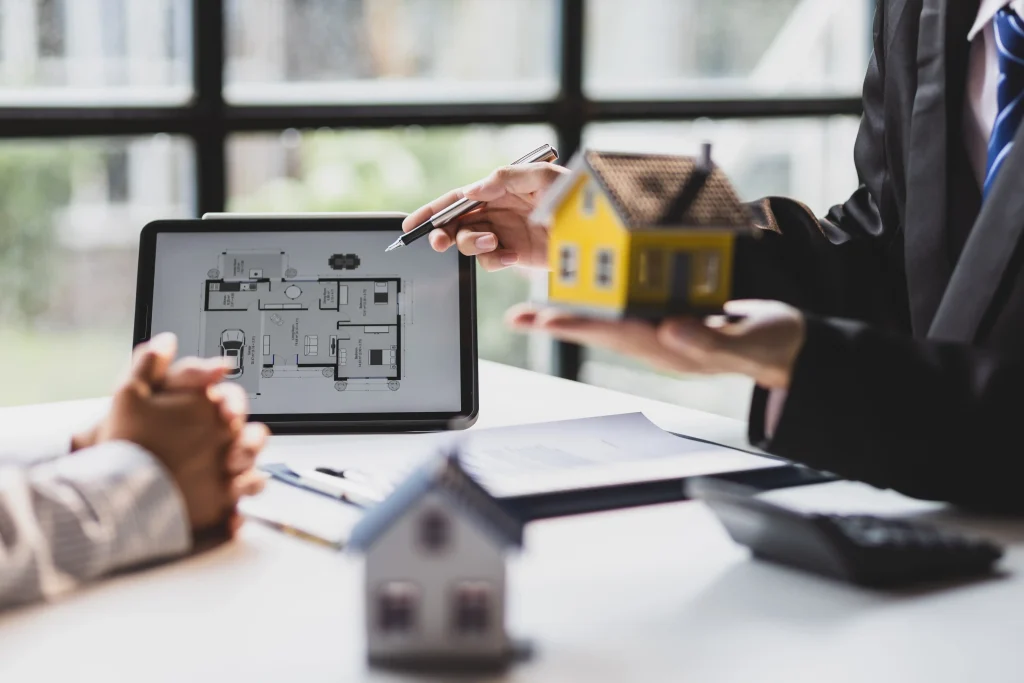 Corretor imobiliário apresenta a planta de um imóvel a um cliente durante uma reunião comercial.